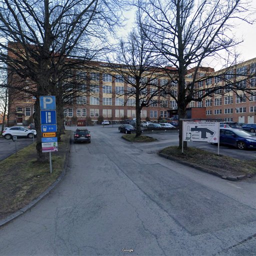 Hatanpään teollisuustalo pihan päässä ja pysäköintialue rakennuksen edessä.